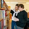 pexels-photo-8199613-8199613 Two young adults reading and researching books in a library environment.
