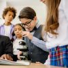 pexels-photo-8617845-8617845 Children in a classroom exploring science with a microscope, emphasizing learning and diversity.